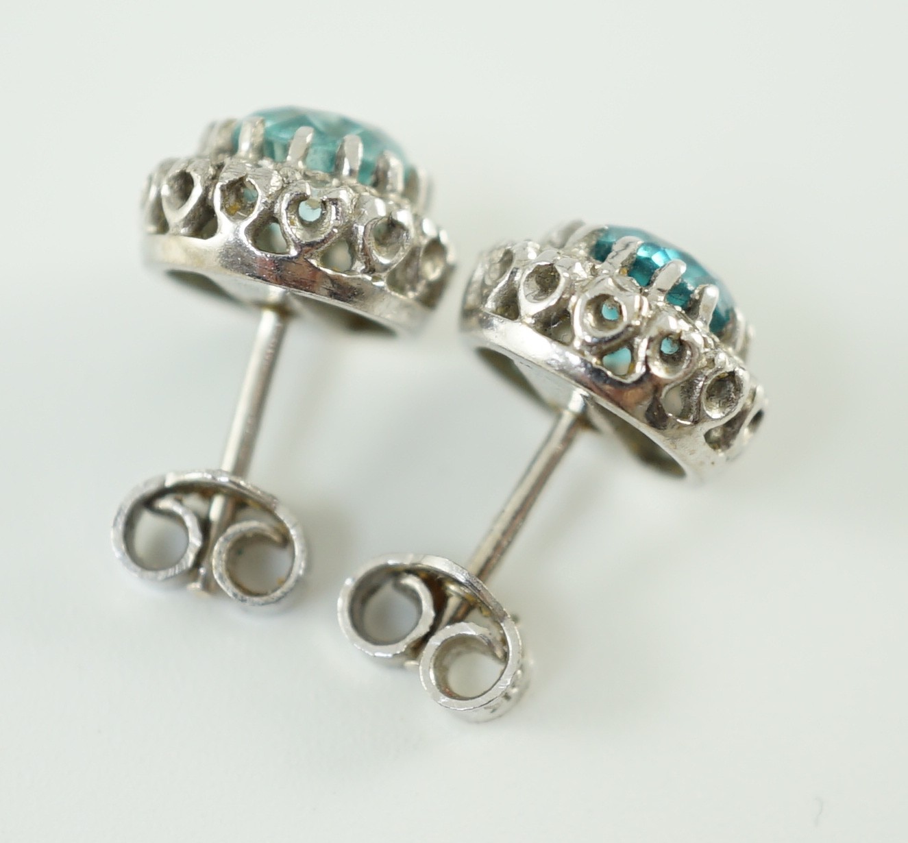 A pair of 18k white gold, blue zircon and diamond set circular cluster ear studs